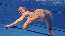 Девушка в купальнике эротично плавает в бассейне